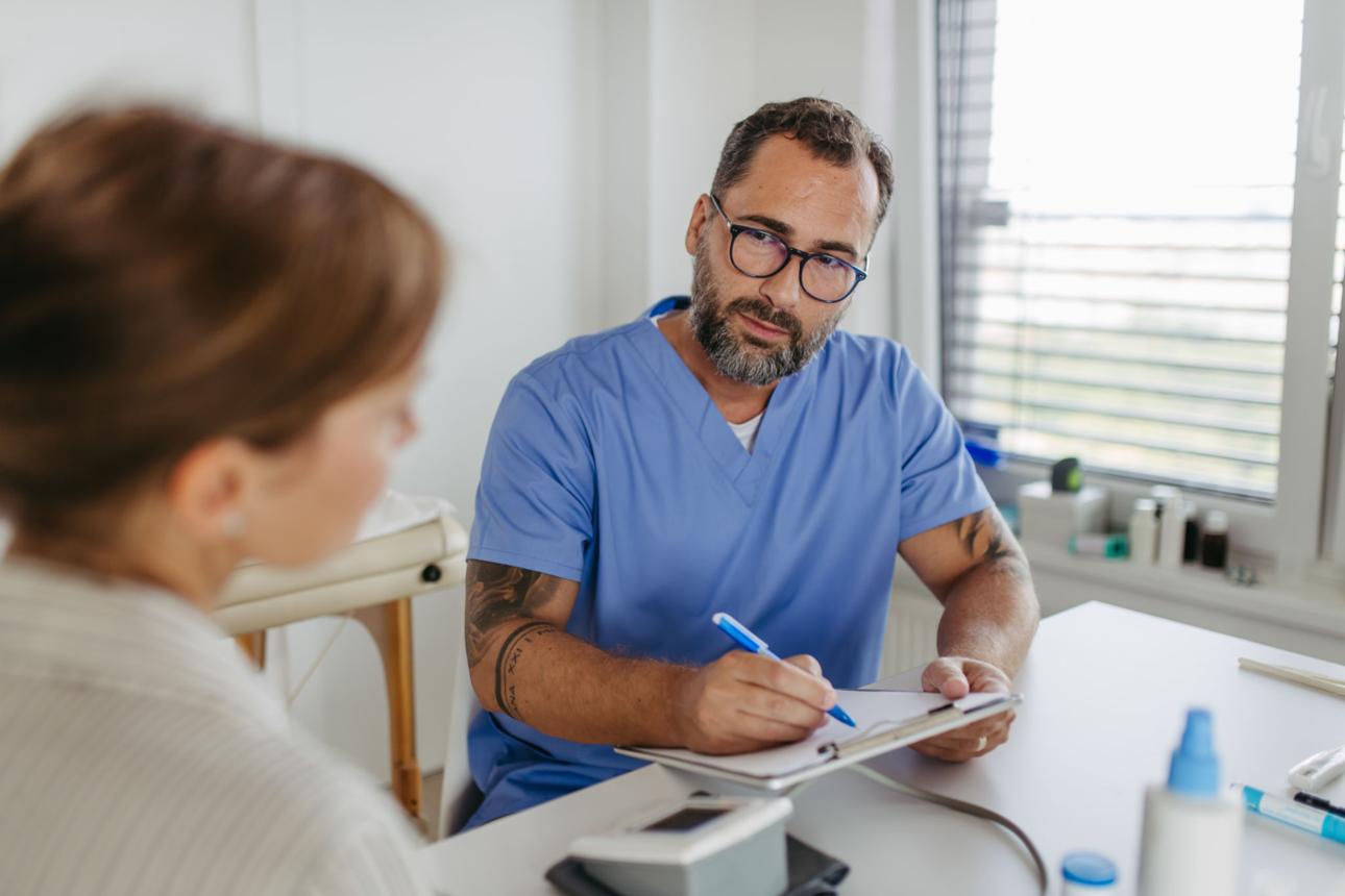 An adult patient talking with a clinician